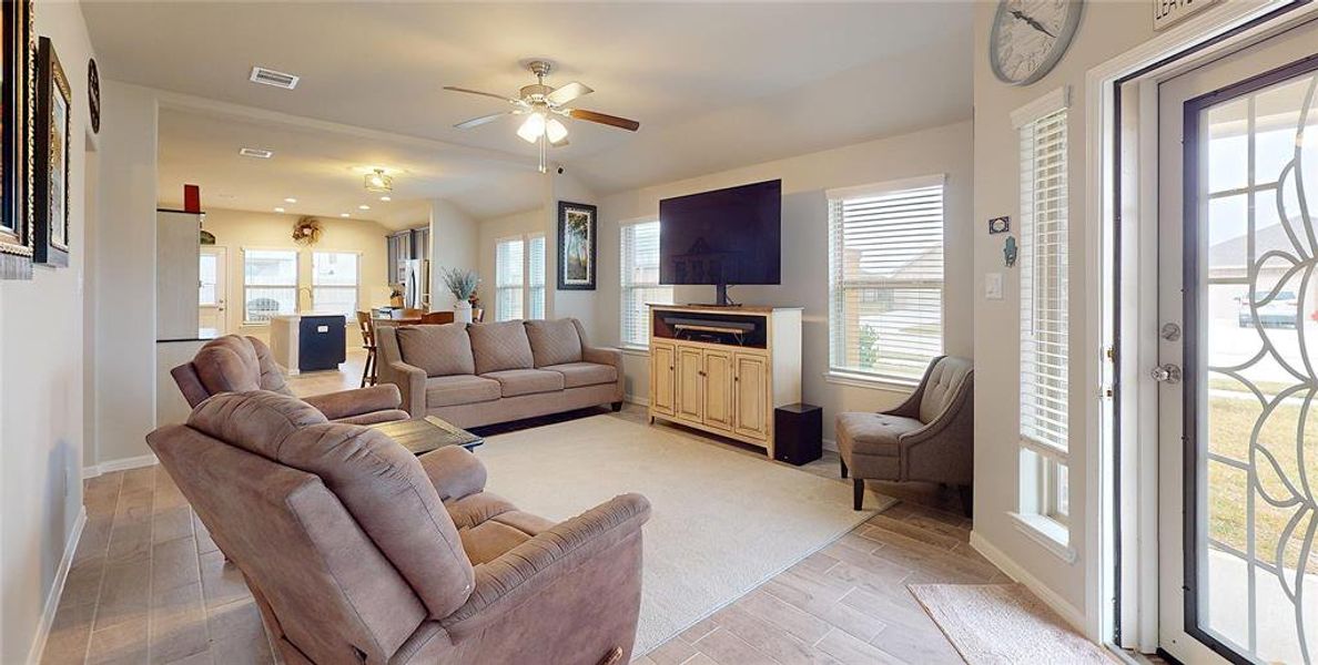 The living area with its functional and beautiful filigree storm door.  Note the wood-look tile flooring.