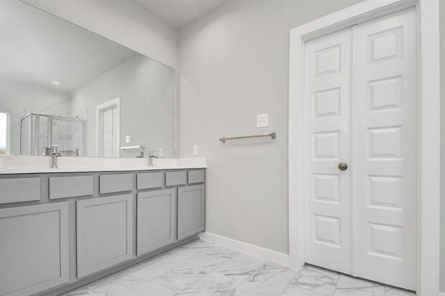 Elegant vanity featuring light countertops, modern hardware, and bright recessed lights. Experience luxury and relaxation in every detail. Sample photo of completed home with similar floor plan. As-built interior colors and selections may vary.