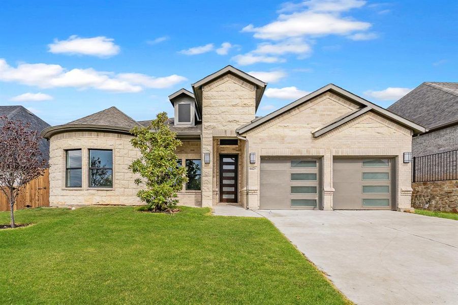 View of front of home with concrete driveway, roof with shingles, and a garage
