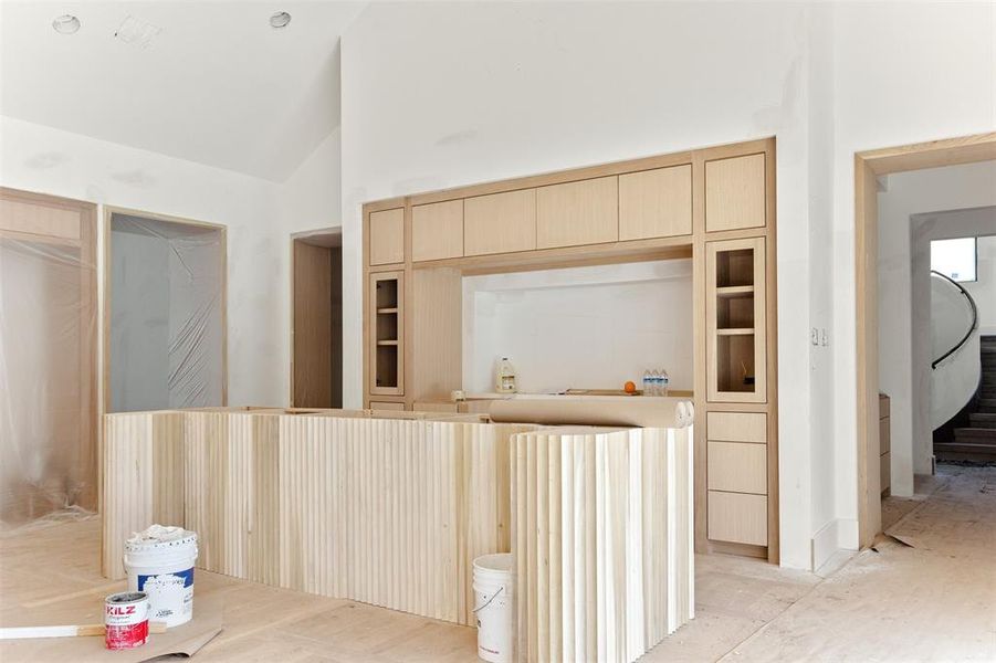 Kitchen with light brown cabinets and high vaulted ceiling