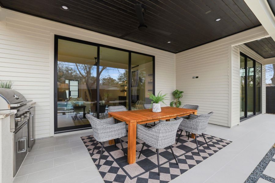 View of patio with outdoor dining area, ceiling fan, and area for grilling