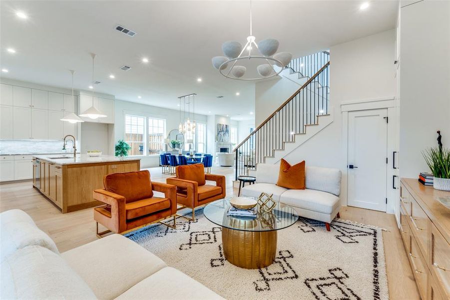 Living room with a chandelier, sink, and light hardwood / wood-style flooring