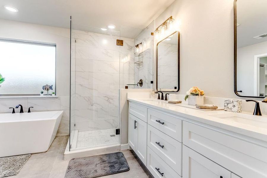 Bathroom featuring tile patterned floors, vanity, and plus walk in shower