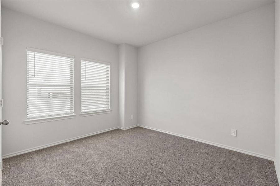 Neutral wall paint and carpeted flooring define this interior space