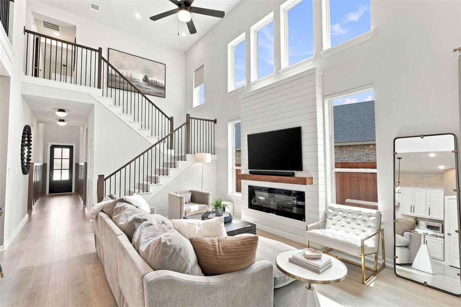 Soaring ceilings, ample amount of windows bringing in natural light with automatic window shades, custom built in electric fireplace with natural flame and shiplap detail surround. Upgraded lighting in hallway, and wainscoting detail in entry hallway