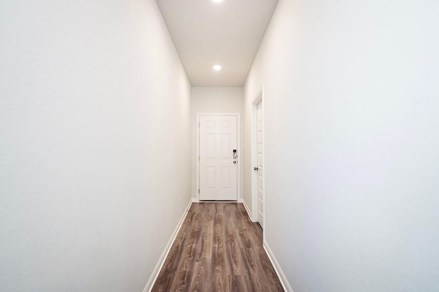 Hall with dark wood-type flooring, baseboards, and recessed lighting Hall with dark wood-type flooring, baseboards, and recessed lighting