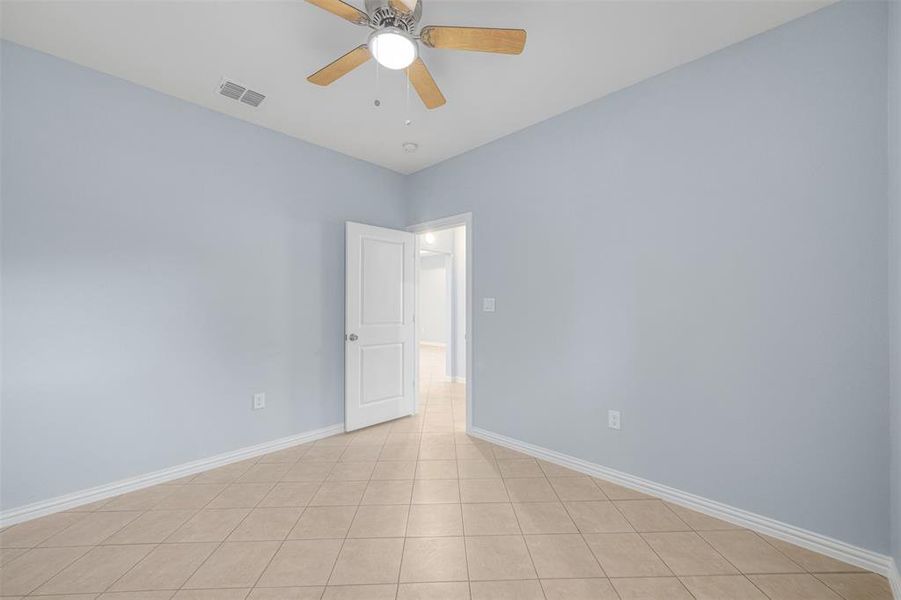 Unfurnished room with light tile patterned floors and ceiling fan