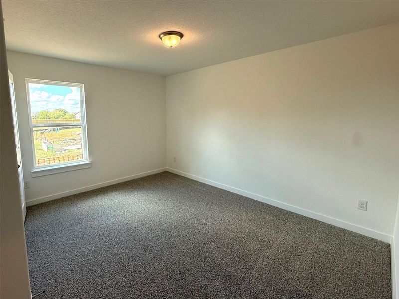 Carpeted spare room with baseboards and a textured ceiling Carpeted spare room with baseboards and a textured ceiling