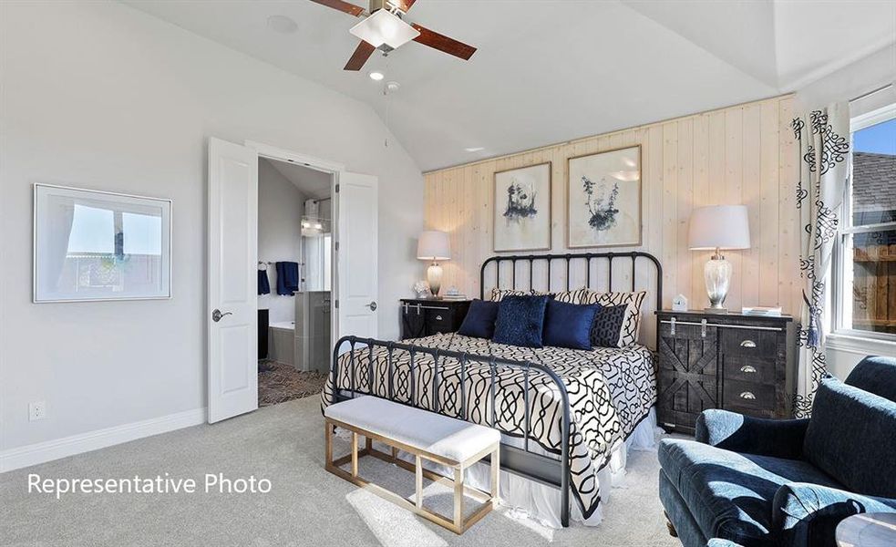 Bedroom with vaulted ceiling, carpet flooring, and wood walls