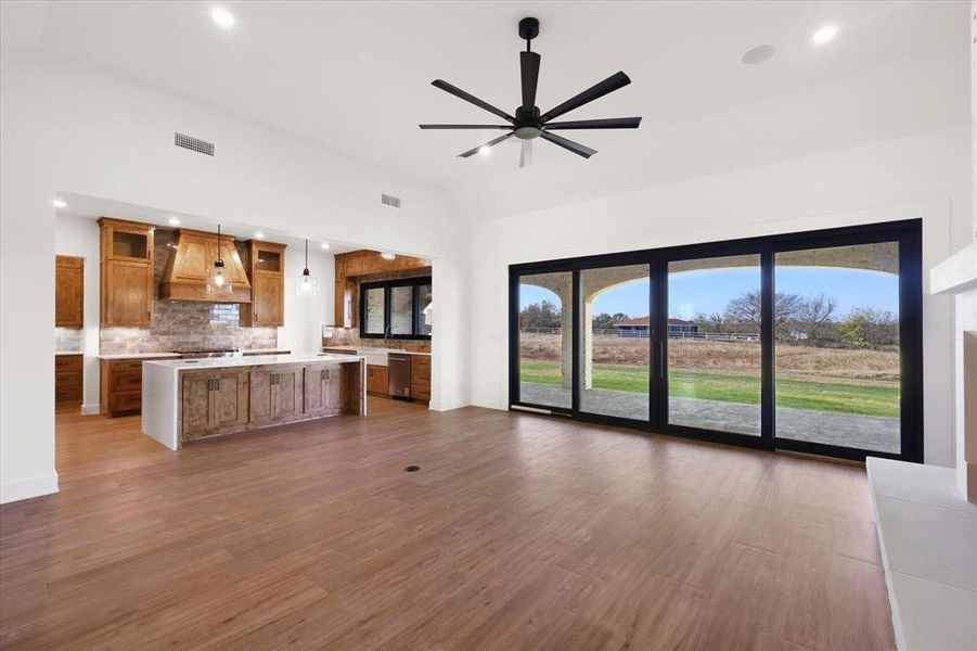 Unfurnished living room with vaulted ceiling, recessed lighting, dark wood-type flooring, and ceiling fan