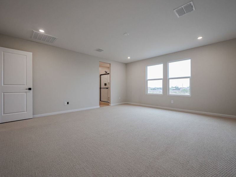 A room with a carpet and a window.