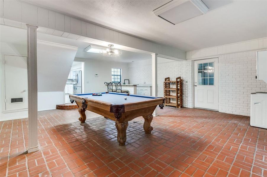 Playroom with brick wall, brick floors, and billiards table