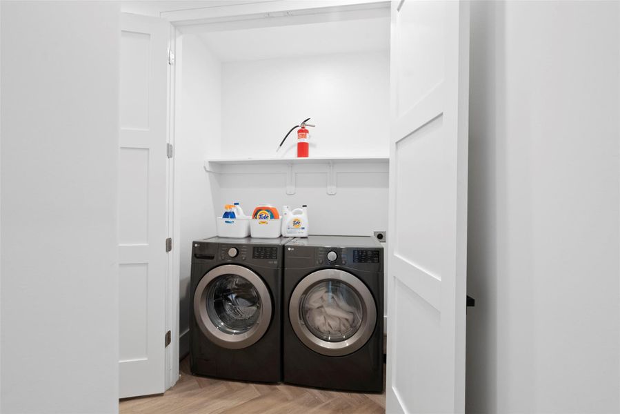 Located on the second floor for ultimate convenience, this built-in laundry nook features a premium front-load washer and dryer, discreetly tucked behind cabinet-style doors that maintain the home's consistent coastal modern aesthetic. A sleek overhead shelf offers practical storage, blending functionality with elevated design. Located on the second floor for ultimate convenience, this built-in laundry nook features a premium front-load washer and dryer, discreetly tucked behind cabinet-style doors that maintain the home's consistent coastal modern aesthetic. A sleek overhead shelf offers practical storage, blending functionality with elevated design.