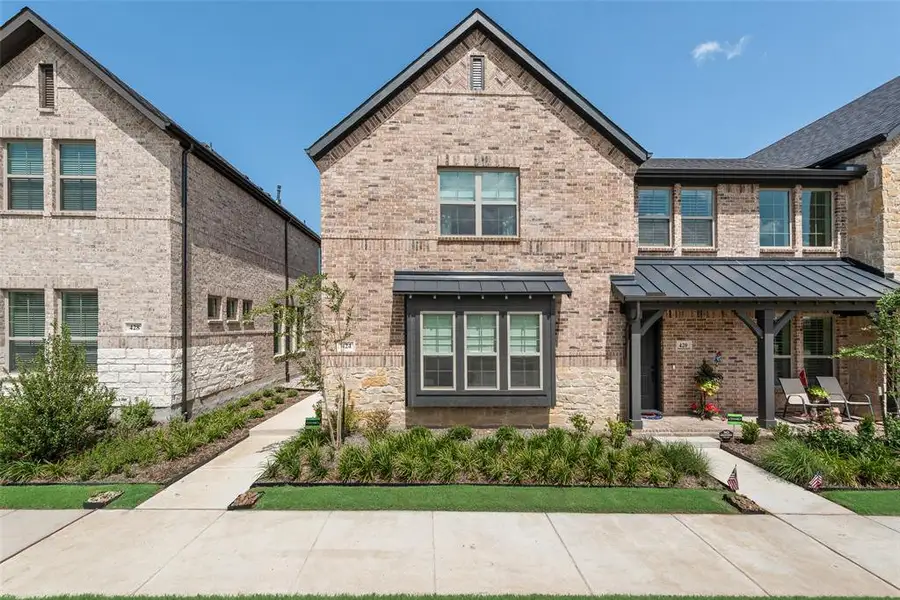 Brick and stone facade featuring a prominent bay window with dark trim Brick and stone facade featuring a prominent bay window with dark trim