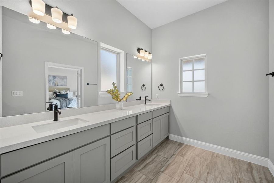 Double vanity featuring dual undermount sinks, stone countertops, and matte black fixtures