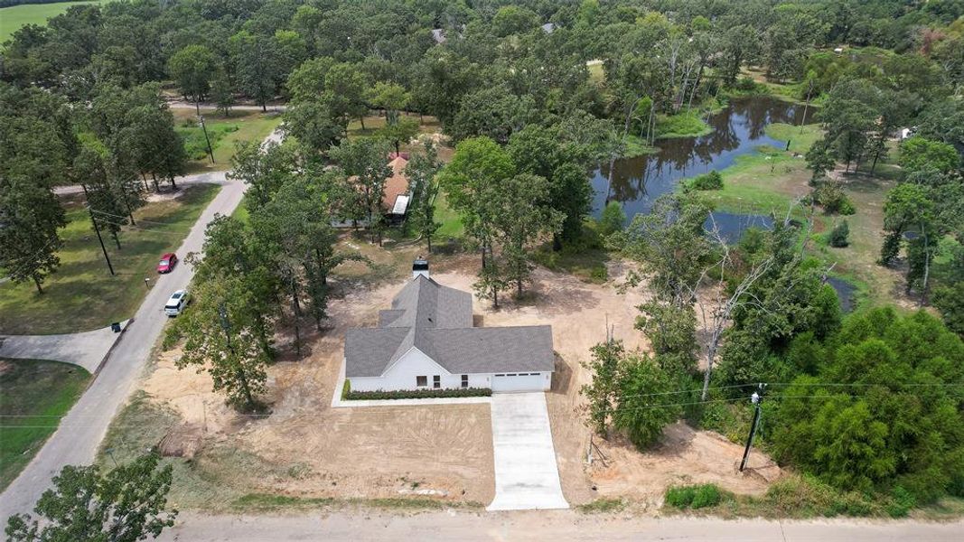 Aerial view of property and surrounding area with a nearby body of water