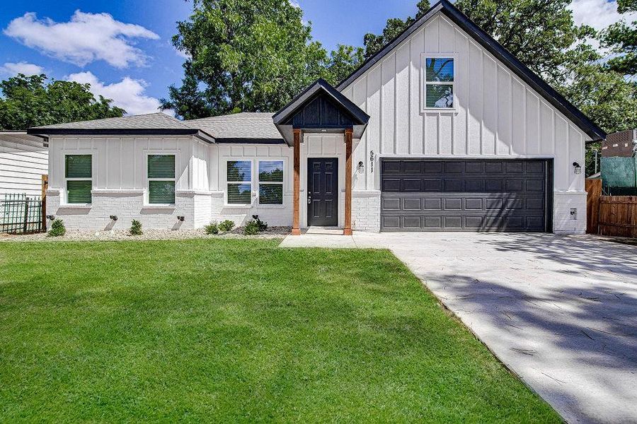 Modern farmhouse featuring a garage and a front yard