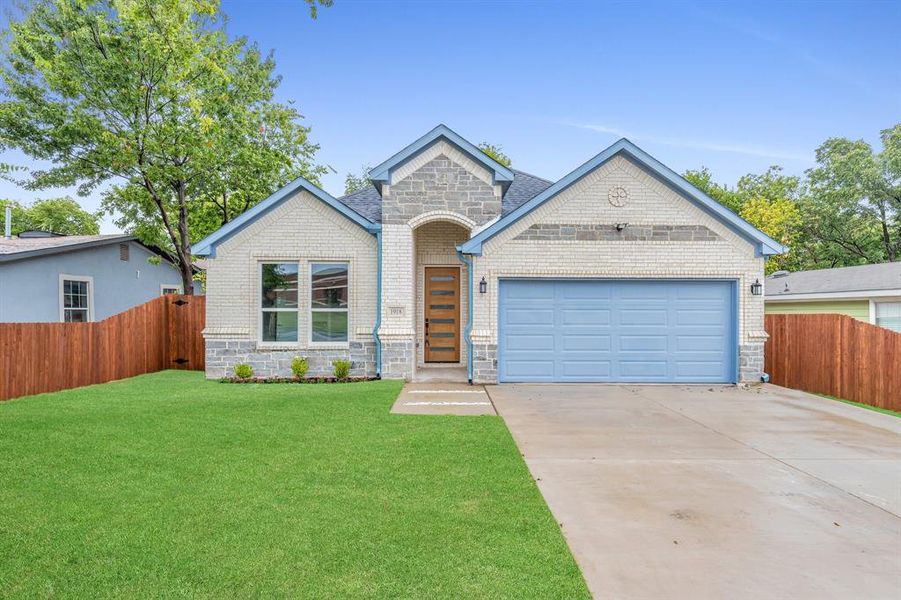 View of front facade with a garage and a front lawn