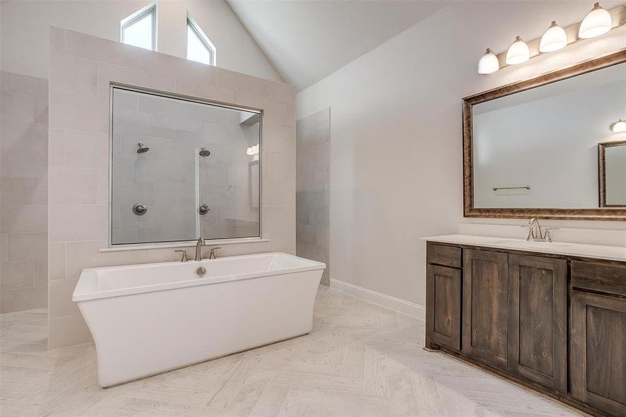 Bathroom with shower with separate bathtub, vaulted ceiling, parquet floors, and vanity