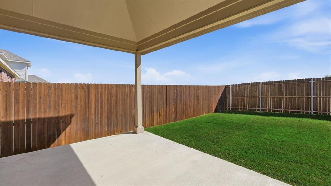 Covered patio with a concrete surface, providing ample outdoor living space