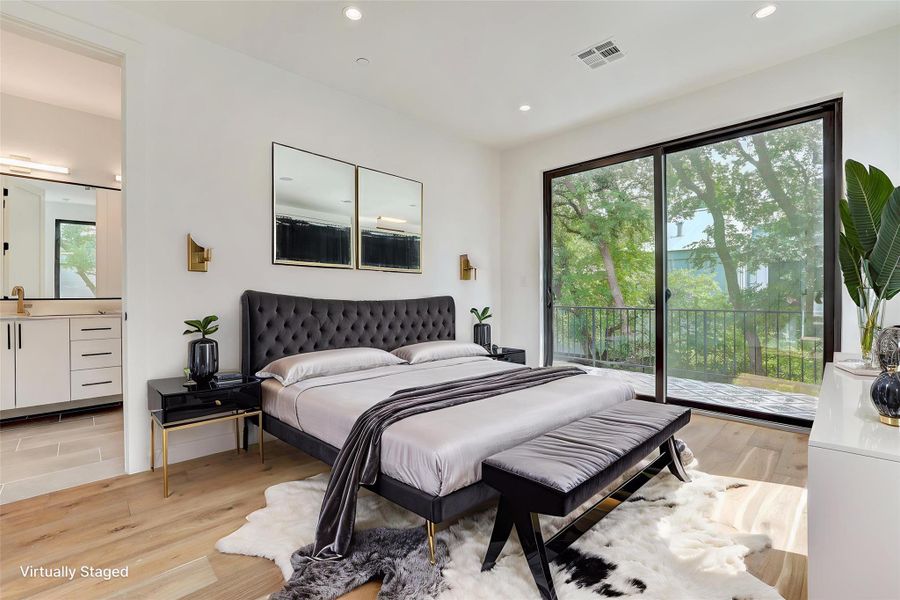 Bedroom with access to exterior, light wood-style floors, recessed lighting, and connected bathroom