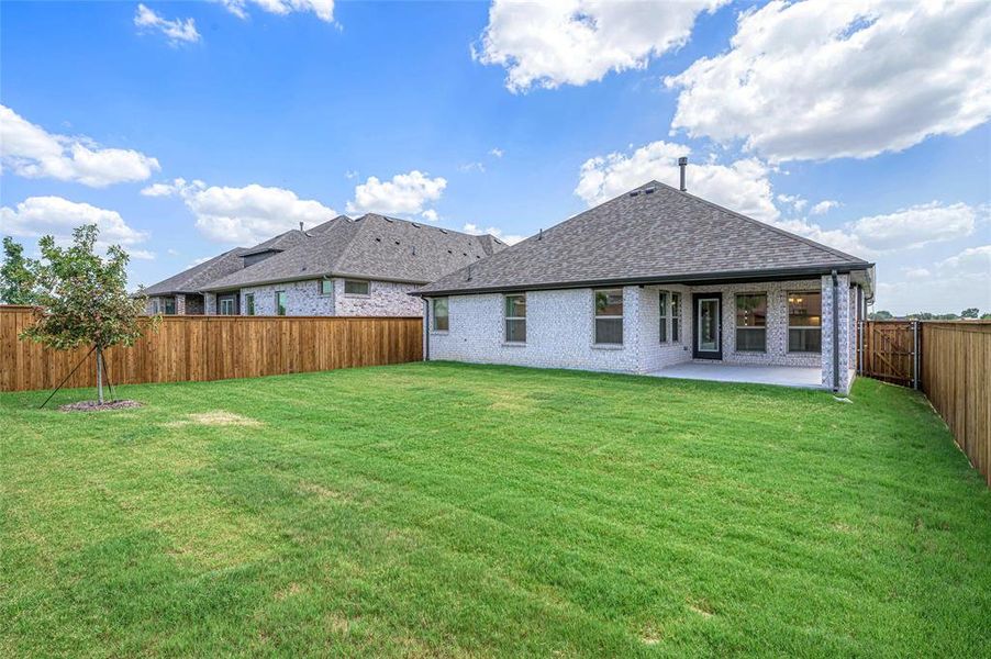 Back of house with brick siding, a fenced backyard, a patio, and roof with shingles Back of house with brick siding, a fenced backyard, a patio, and roof with shingles