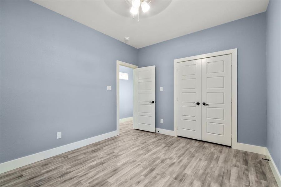 Unfurnished bedroom with light hardwood / wood-style flooring, a closet, and ceiling fan