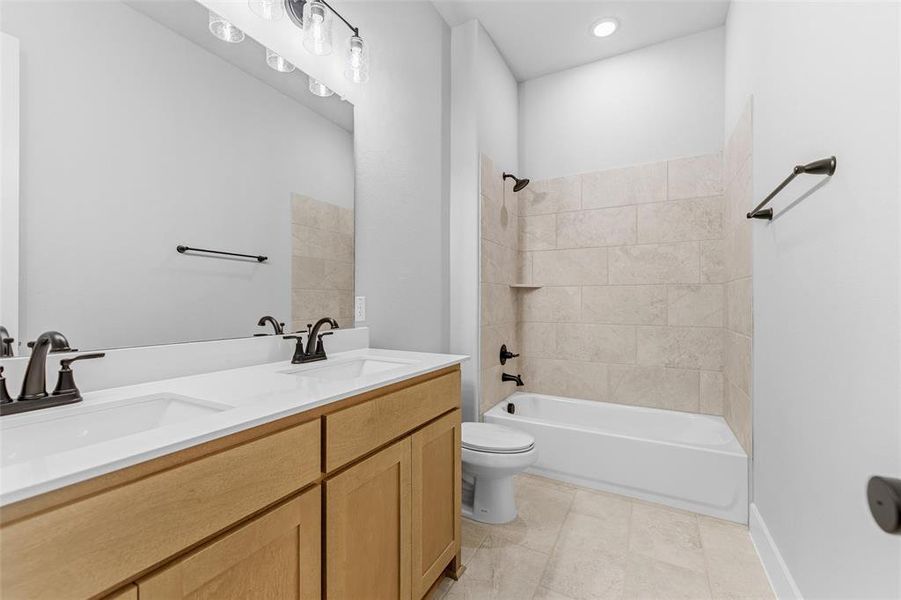 Full bath featuring double vanity, bathing tub / shower combination, and light tile patterned floors