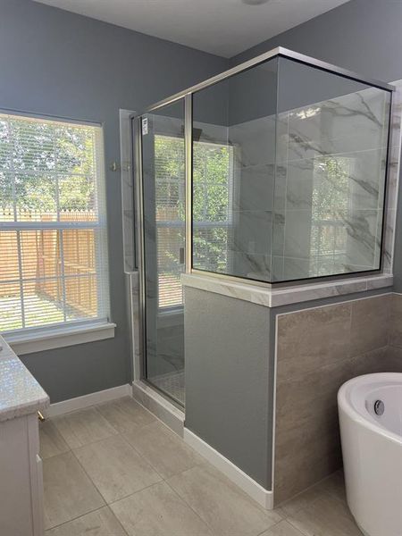 Full bathroom with a shower stall, a freestanding tub. Full bathroom with a shower stall, a freestanding tub.