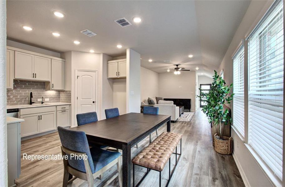 Open-concept living space featuring wood-finish flooring, recessed lighting, and a vaulted ceiling