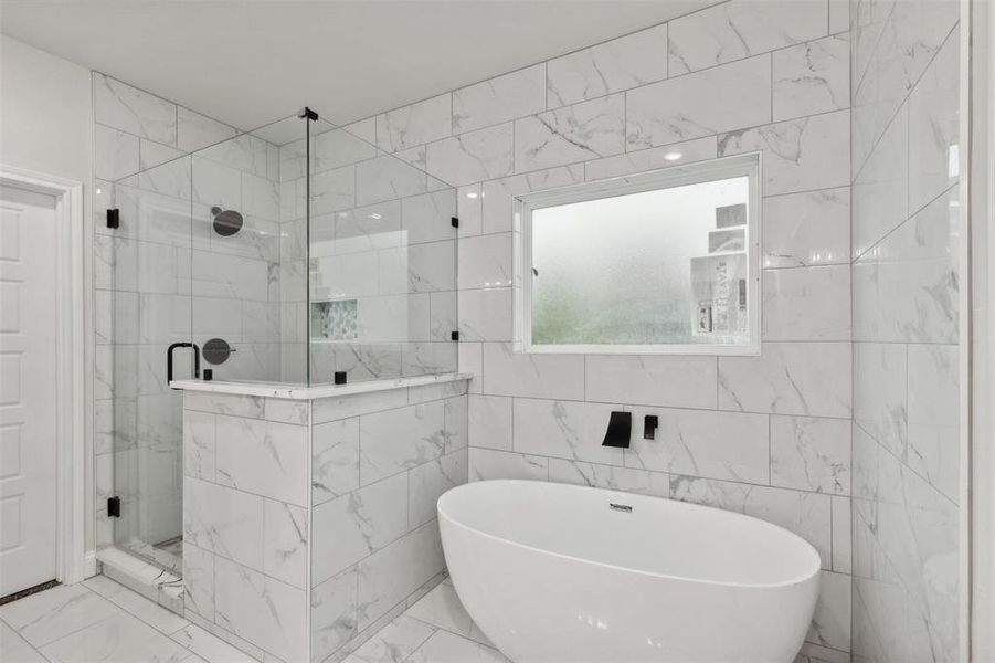 Bathroom featuring tile walls and independent shower and bath