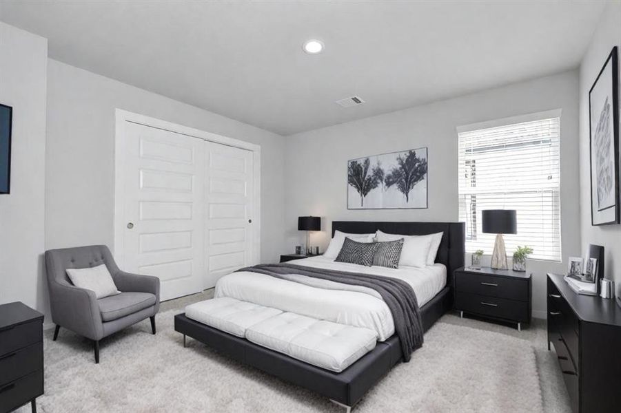 Secondary bedroom with neutral paint, plush carpet, and large windows for natural light.