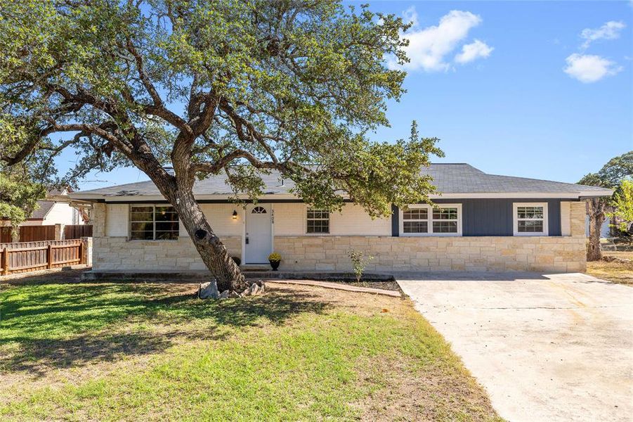 Single story home with stone siding and roof with shingles