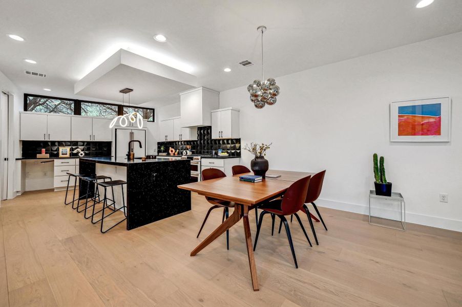 Dining room with light wood-style flooring, recessed lighting, and a chandelier