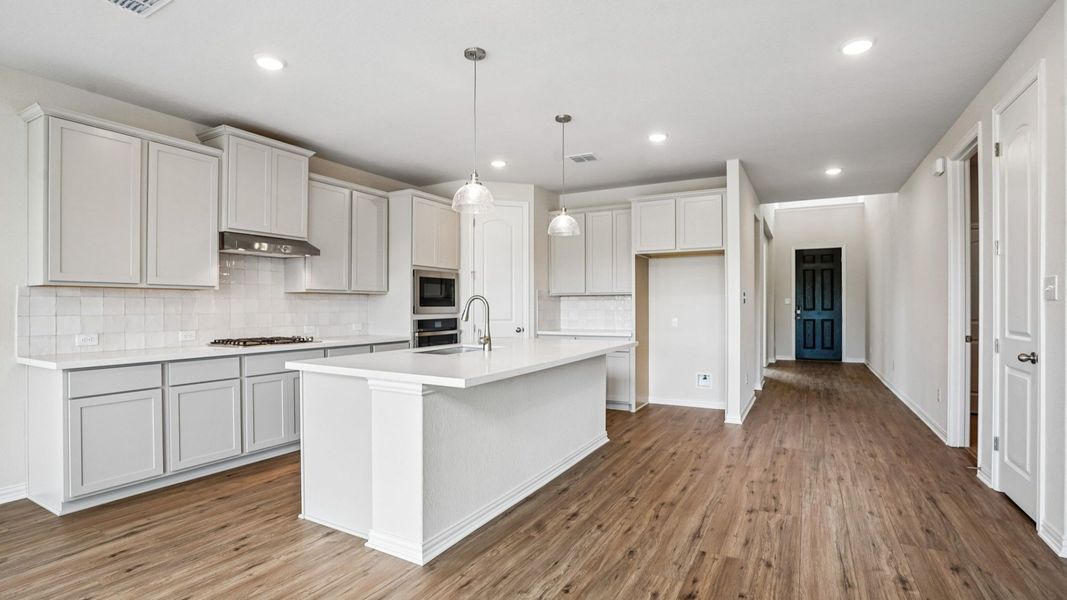 Modern Kitchen Features Built-in Appliances, Pendant Island, and Center Island