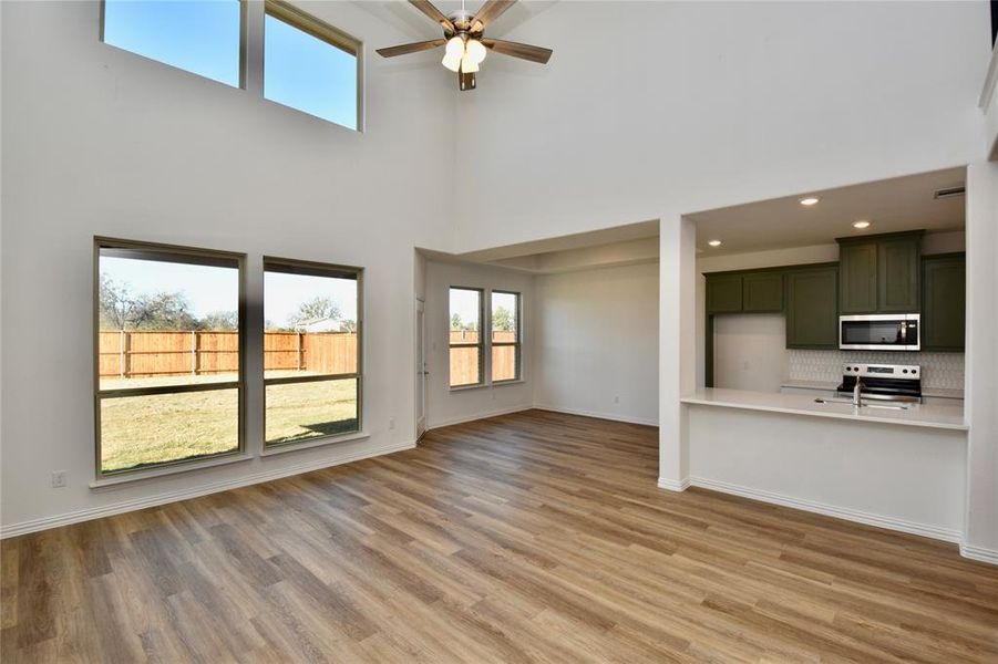 Unfurnished living room featuring a ceiling fan and light wood-style floors