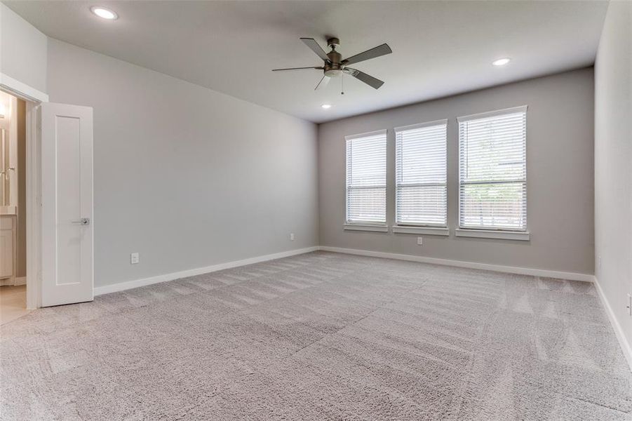 Empty room featuring light carpet and ceiling fan