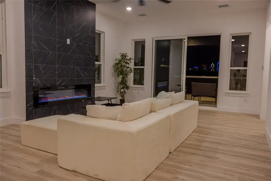 Expansive living area showcasing stunning interior panoramic views of Downtown Dallas, complemented by a covered outdoor patio ideal for hosting gatherings or enjoying the skyline in comfort. Expansive living area showcasing stunning interior panoramic views of Downtown Dallas, complemented by a covered outdoor patio ideal for hosting gatherings or enjoying the skyline in comfort.