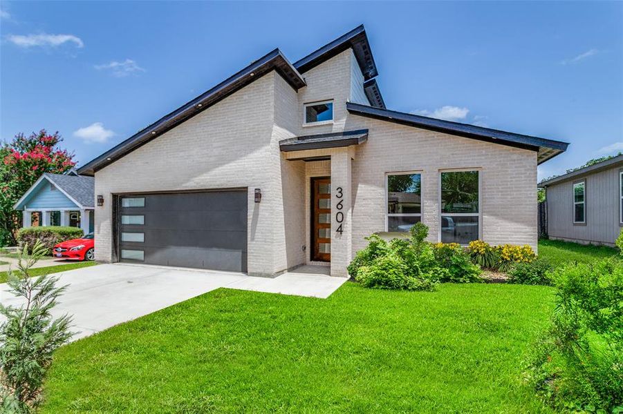 Modern home featuring a garage and a front yard