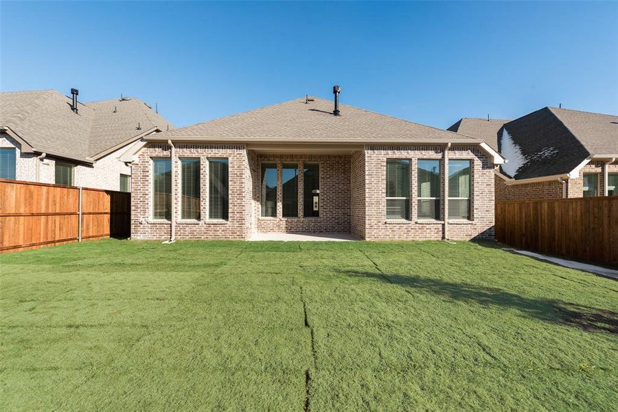 Rear view of house featuring a yard and a patio area