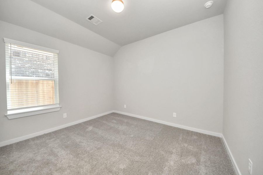 Secondary bedroom features plush carpeting, large windows that let in plenty of natural light, bright paint, and spacious closets. Sample photo of completed home with similar floor plan. Actual colors and selections may vary.