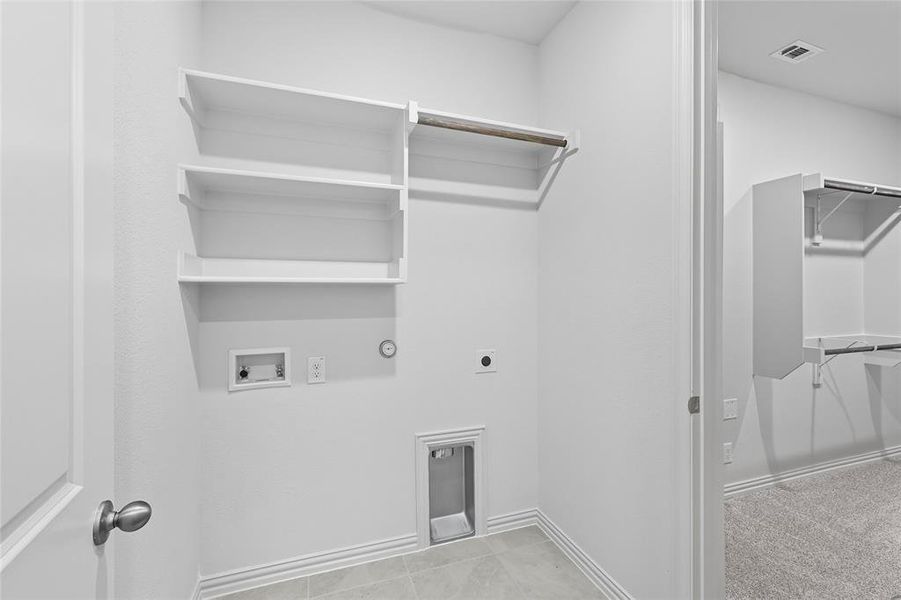 Washroom featuring hookup for a gas dryer, electric dryer hookup, hookup for a washing machine, and light tile patterned floors Washroom featuring hookup for a gas dryer, electric dryer hookup, hookup for a washing machine, and light tile patterned floors