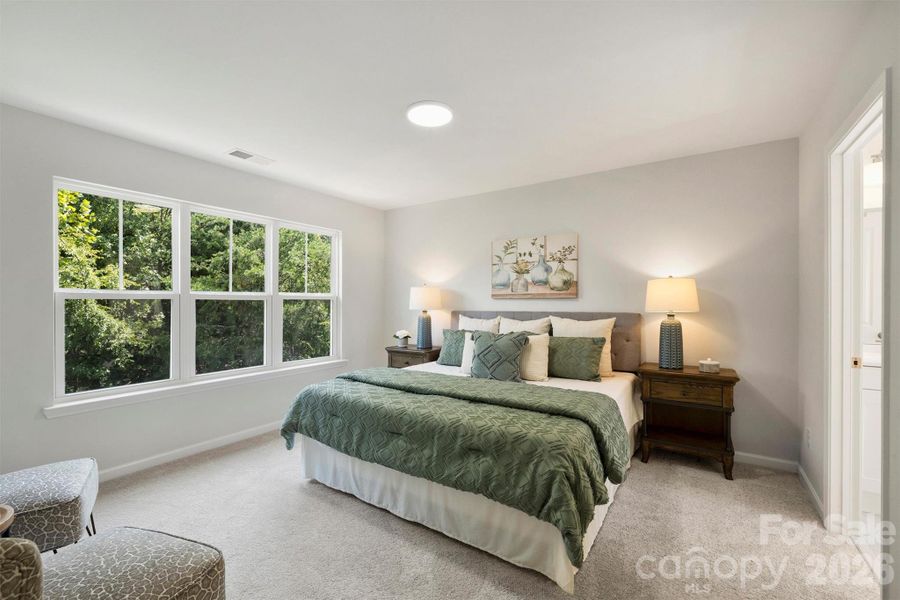 Primary bedroom featuring large windows and an ensuite bathroom