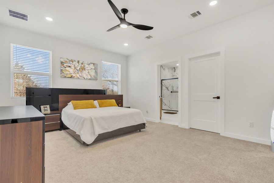 Bedroom featuring light colored carpet, a ceiling fan, ensuite bathroom, and recessed lighting