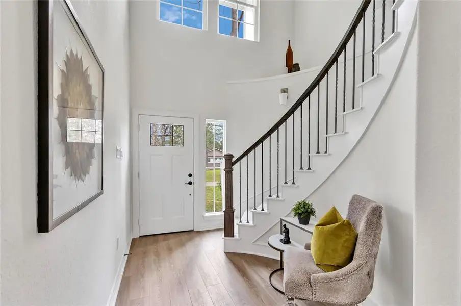 Elegant entryway featuring a spiral staircase and inviting front door.