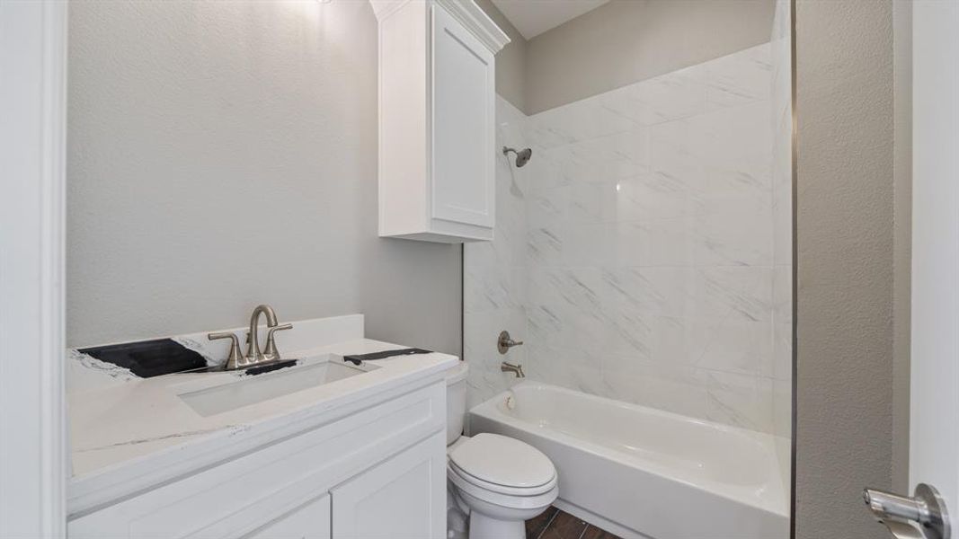 Bathroom featuring shower / bathing tub combination, vanity, and toilet