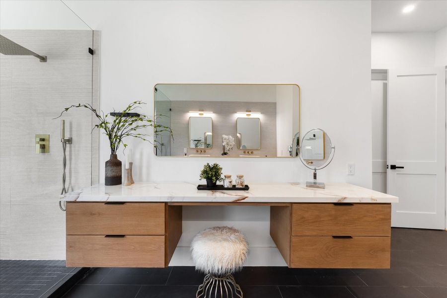 This makeup countertop in the primary bathroom features a modern design with a large, elegant mirror and a Silestone countertop. The wooden, soft close cabinetry provides ample storage, complemented by stylish lighting, creating a serene and luxurious atmosphere. This makeup countertop in the primary bathroom features a modern design with a large, elegant mirror and a Silestone countertop. The wooden, soft close cabinetry provides ample storage, complemented by stylish lighting, creating a serene and luxurious atmosphere.