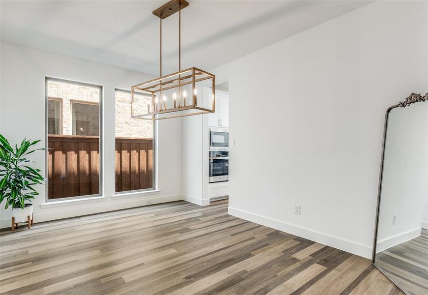 Unfurnished dining area featuring a chandelier and light wood-style floors