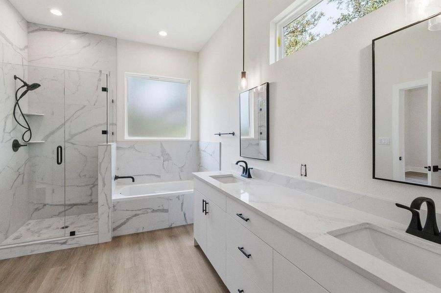 Luxurious ensuite features a spacious shower, a deep soaking tub, and a long dual-sink vanity. Luxurious ensuite features a spacious shower, a deep soaking tub, and a long dual-sink vanity.