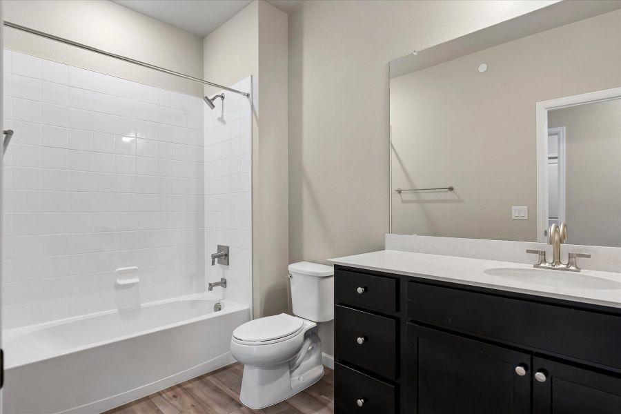 A bathroom with a tub sink and toilet.